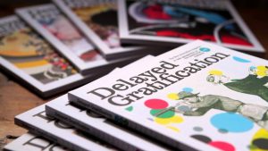 Delayed Gratification dergisinin farklı sayıları bir masa üzerine dizilmiş.