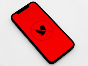 Telefon ekranında kırmızı üzerine siyahla Twitter logosu ve üzerinde yasaktır işareti.