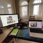 201inci bülteni yazdığım çalışma masasının fotoğrafı. Sol tarafta ikinci mönitör, kalemler ve başka ekstralar var. Ön ve sağ taraftaki masada macbook bilgisayar, bir not defteri ve üstünde dolmakalem, yanında Algoritmalar Ne İster isimli bir kitap, onların arkasına doğru da Kindle, Raspberry Pi gibi ekstra eşyalar duruyor.