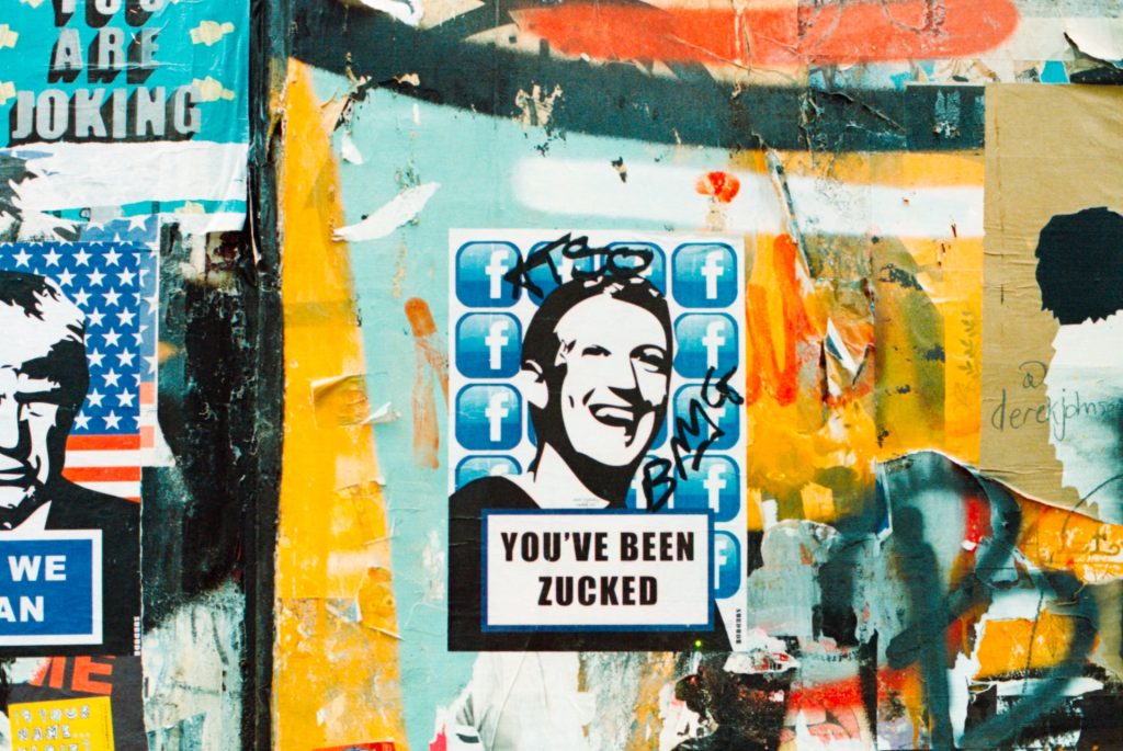 Bir duvara yapıştırılmış posterde Facebook logolarının önünde Zuckerberg'in gülen bir fotoğrafının siyah beyaz hâli eklenmiş ve altında "You've Been Zucked" yazıyor.