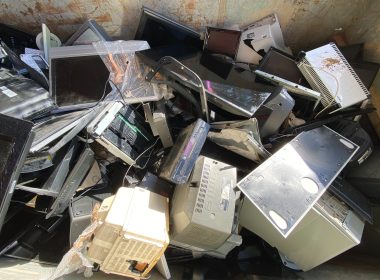 Bir çöp konteynerinin içerisinde bir yığın eski ve kırık bilgisayar parçaları yığılmış olarak görülüyor.