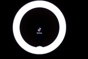 Karanlık bir odanın içerisinde yanan ring light'ın ortasında TikTok logosu görülüyor.