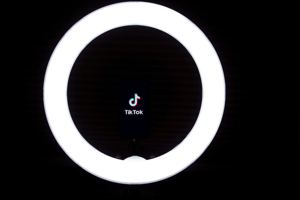 Karanlık bir odanın içerisinde yanan ring light'ın ortasında TikTok logosu görülüyor.
