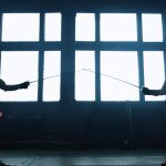 Kılıçlarının ucu birbirine değen iki eskrimcinin silüeti.