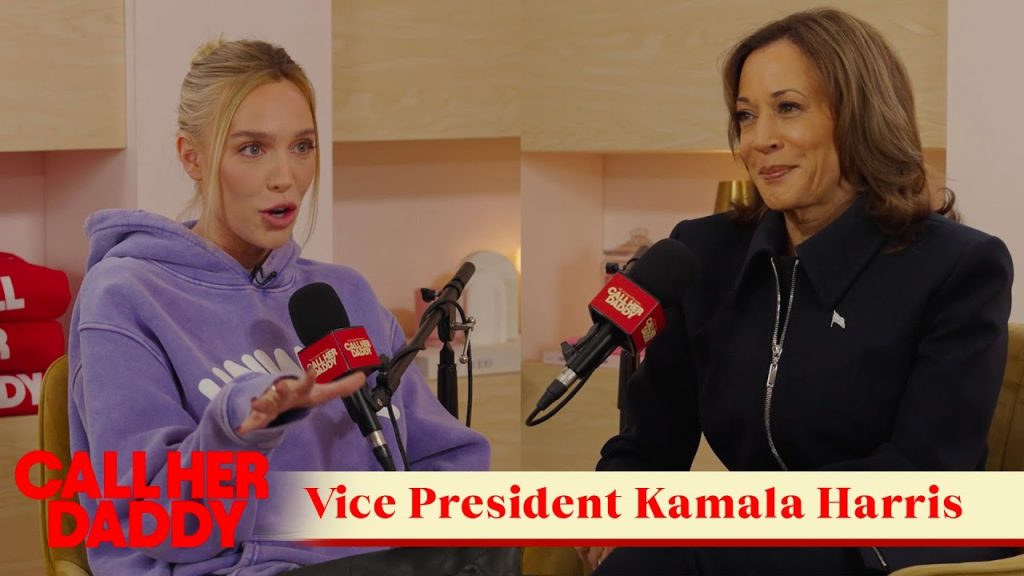 Kamala Harris'in Call Her Daddy podcastının sunucusu ile karşılıklı göründüğü bir tanıtım görseli. Harris siyah bir takım elbiseyle, sunucu Alex Cooper ise eflatun bir hoodie ile görülüyor.
