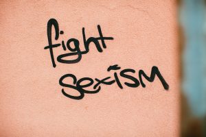 Somon rengi bir duvarda siyah sprey boyayla yazılmış graffiti "fight sexism" diyor.